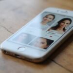 Smartphone zeigt Dating Profile auf einem hölzernen Tisch